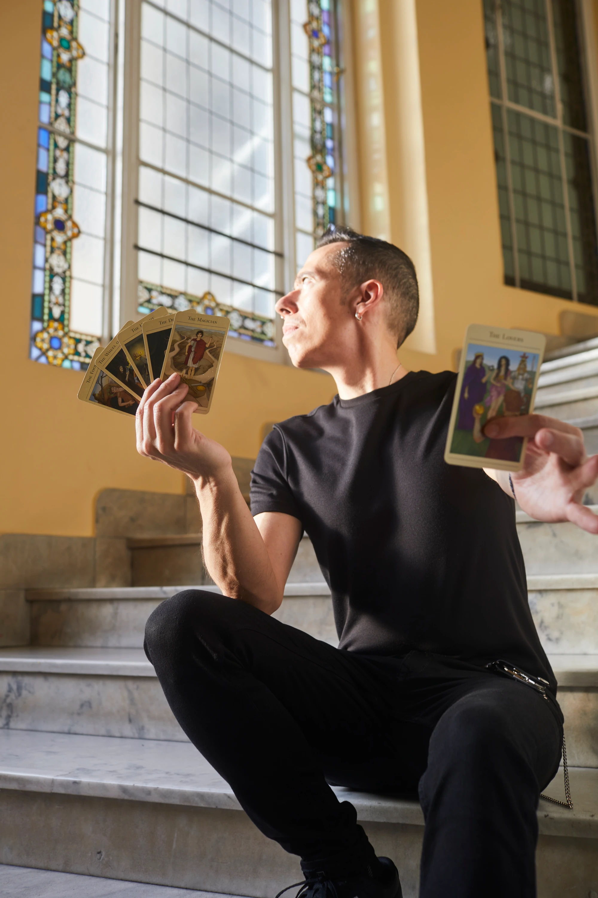 Fito Crawford con cartas en las manos, junto a una vidriera