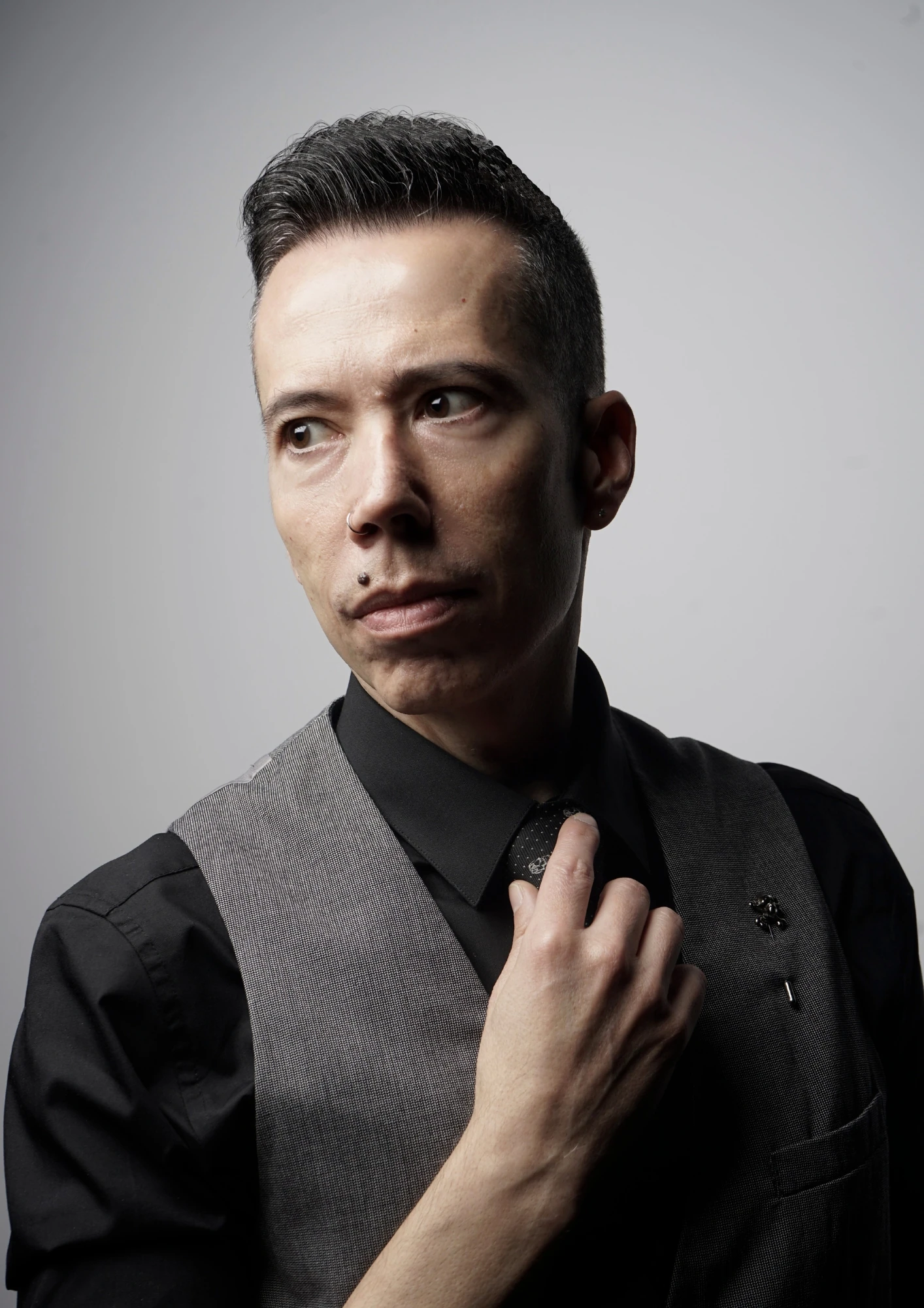 Retrato de Fito Crawford con chaleco gris, ajustándose la corbata